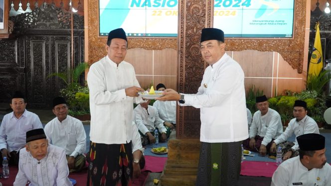 
 Rais Syuriah PCNU Jepara KH Khayatun Abdullah Hadziq menerima tumpeng dari Pj Bupati Jepara H Edy Supriyanta saat resepsi Hari Santri Nasional 2024 yang digelar di Pendopo Kabupaten Jepara, Selasa (22/10/2024).